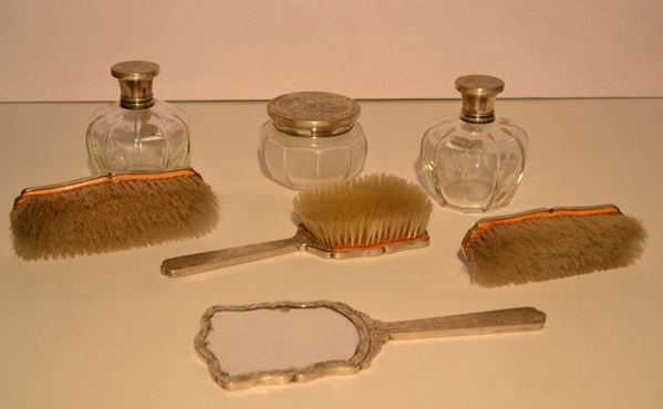 Servito da toilette, in vetro tagliato e argento cesellato ed inciso a motivi vegetali, composto da uno specchio, due flaconi, un portacipria e  tre spazzole (7)