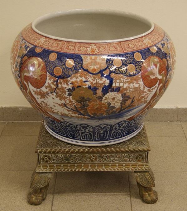 Cachepot orientale, in porcellana, inizi sec. XX, su base in legno, rivestita in metallo, su quattro piedi, diametro cm 58