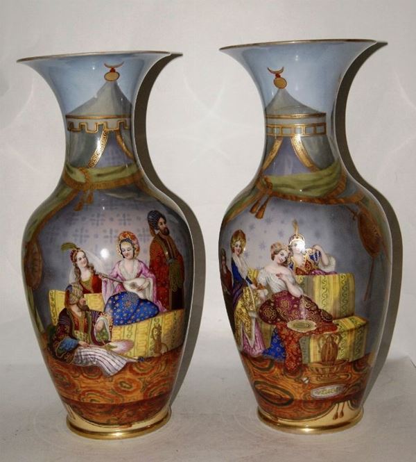 Coppia di vasi, Francia, primi sec.XX, in porcellana policroma, decorati a figure entro tenda, bordi dorati, alt. cm 49, uno restaurato(2)
