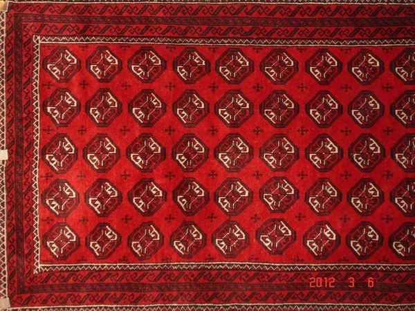 Tappeto persiano turcomanno di vecchia manifattura, fondo rosso, a motivo geometrico, cm 302x107