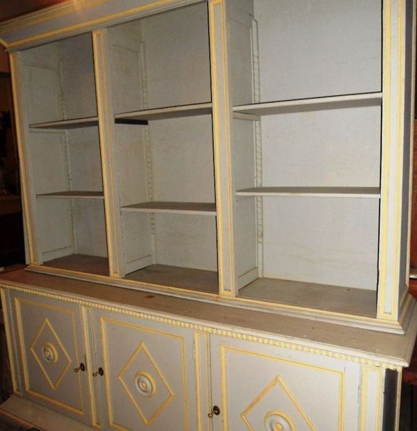 Libreria, sec. XX, in legno laccato bianco, a tre sportelli, vani a giorno, cm 224x60x233