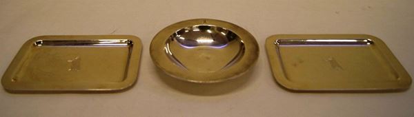 Coppia di vassoietti rettangolari, in argento, con bordi sagomati e al centro orso inciso, e Posacenere tondo, in argento, sul bordo orso inciso, argentiere Del Vecchio, tot. gr 1100,00 (3)