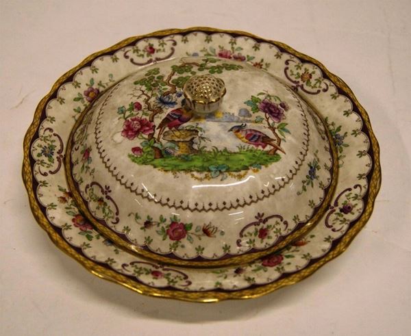 Legumiera circolare, con coperchio in porcellana decorata in policromia, con fiori, volute e due volatili in un paesaggio lacustre, diam. cm 22, filata