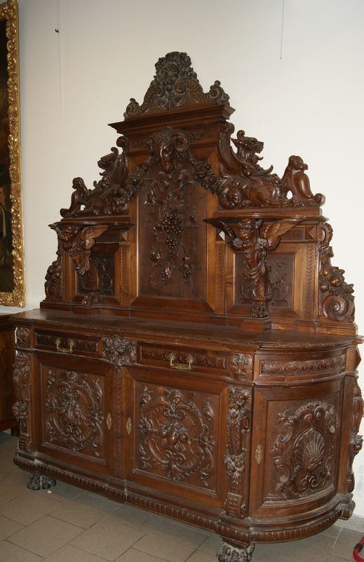 Credenza, Italia centrale, sec. XIX, in legno riccamente intagliato a figure, frutta e fiori, a quattro sportelli, due cassetti e alzata con due piani a giorno, piedi a zampe feline, cm 234x60x250