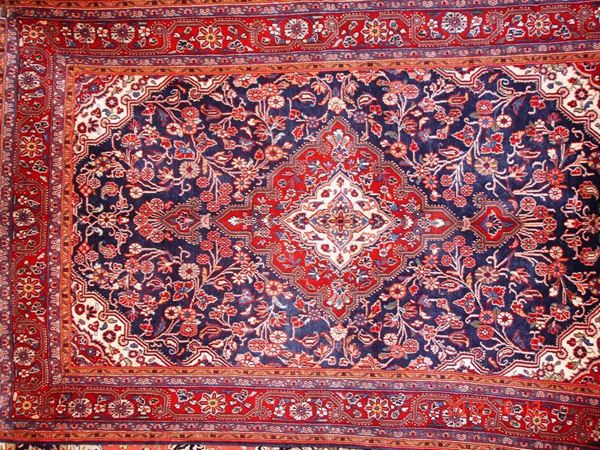 Tappeto persiano sarugh, di vecchia manifattura, fondo blu a motivo floreale, bordura rossa e celeste, cm 205x130