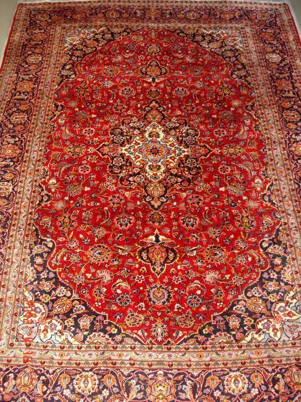 Tappeto persiano keishan, di vecchia manifattura, fondo rosso, a motivo floreale, con medaglione centrale e bordura blu, cm 360x255