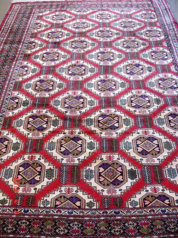 Tappeto kazak, di vecchia manifattura, fondo rosso, campo a motivo geometrico, con vari medaglioni ripetuti sul campo multicolore, cm 385x303