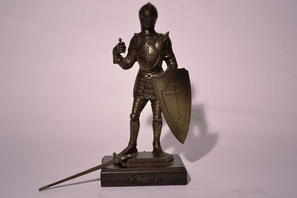 Scultura, sec. XX, in bronzo forgiato a cavaliere in armatura con scudo, base rettangolare in legno, alt. cm 42, danni