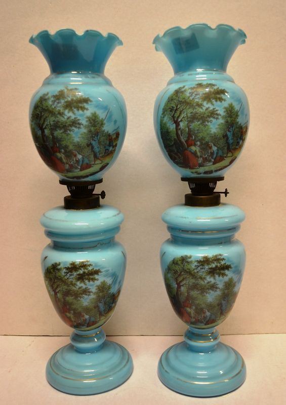 Coppia di lumi a petrolio, fine sec. XIX, in opalina blu decorata a scene di vita contadina entro paesaggi, alt. cm 54,5, uno scartoccio mancante(2)