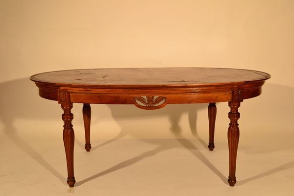 Tavolo da pranzo, sec. XX, in noce, piano ovale, ricoperto di pelle, gambe tornite, cm 180x110x76, lievi danni al piano in pelle