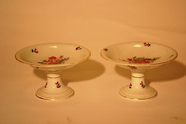 Coppia di alzate, manifattura Ginori, 1880, in porcellana bianca con bordi oro decorata da fiori in policromia, alt. cm 14, bordi oro consunti (2)
