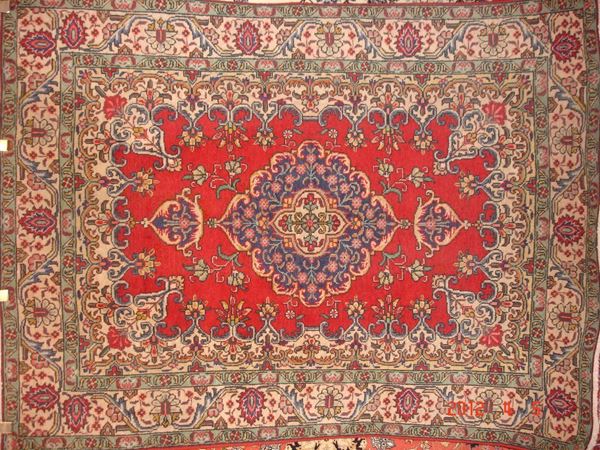 Tappeto persiano tabriz, di vecchia manifattura, fondo rosso, a motivo floreale con medaglione centrale blu e beige, bordura beige e verde, cm 195x145