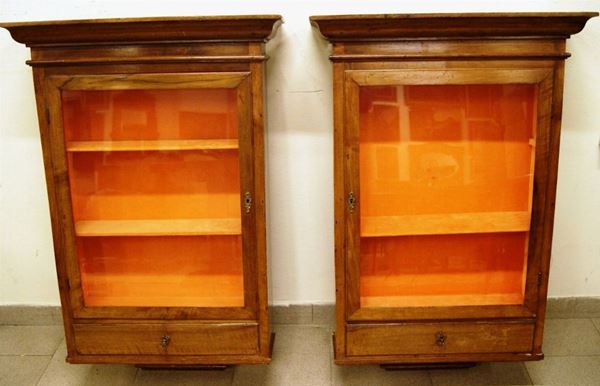 Coppia di vetrinette pensili, Italia settentrionale, sec. XIX, in noce, a uno sportello con vetro ed un cassetto, cm 67x21x106, pianetto mancante(2)
