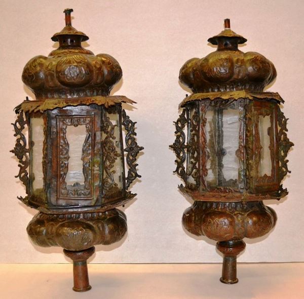 Coppia di lanterne, Veneto, sec. XVIII, di forma ottagonale, in rame        sbalzato decorate a motivi floreali e volute traforate, alt.cm 57, complete di vetri originali (2)