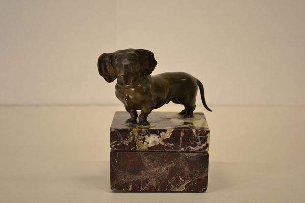 Statuina, sec. XX, in bronzo realisticamente modellato come un bassotto, su base quadrata in marmo, alt. cm 14
