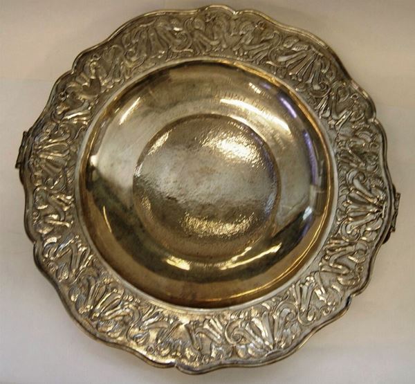 Grande centrotavola, Cile, in argento, bordo sagomato con decorazione a foglie e frutta, a due manici, poggiante su tre piedi, al centro dedica risalente al 1947, diam. cm 51, gr. 2550