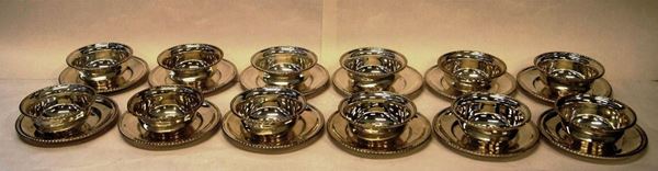 Dodici coppette con dodici piattini, in argento, bordo lavorato, gr. 2190, diam. piattini cm 15,5(24)