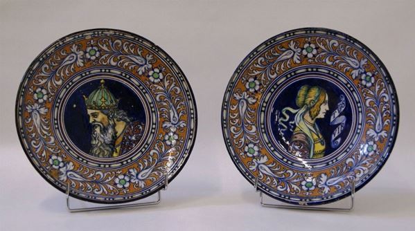 Coppia di piatti, Faenza, sec. XX, manifattura Zama,  in maiolica decorata a figure e fiori, diam. cm 29(2)