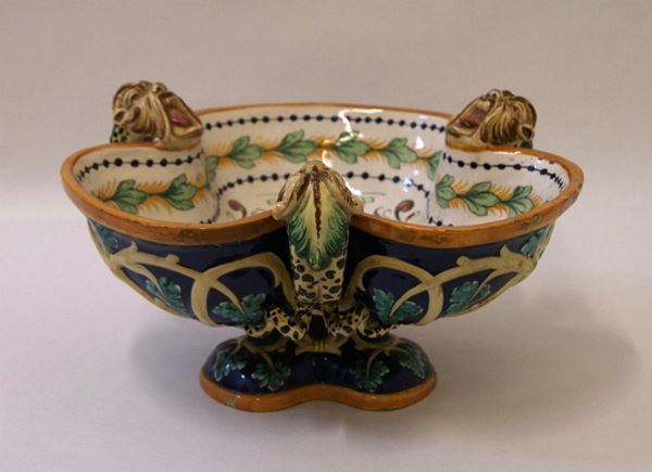 Alzata, sec. XX, in maiolica manifattura Fantechi, con base a tripode decorata a fiori e con draghi in altorilievo, cm 33x19, piccoli difetti