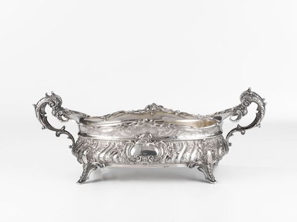 Vaschetta centrotavola, Germania inizi sec. XX, di forma ovale sagomata, in argento sbalzato e cesellato a volute di foglie e fiori, anse a  doppio     ricciolo, base a quattro piedini, g 710, interno in metallo
