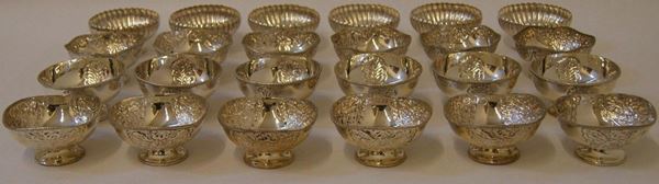 Sei coppette, in argento, cesellate a motivo fogliaceo, Sei coppette, in argento, con corpo a fasce bombate, Sei coppette, in argento, cesellate a fiori e pampini d'uva, bordo ondulato, e altre Sei coppette, in argento, cesellate a fiori, dal bordo ondulato, diam. 9 cm, gr. 1550 complessivi