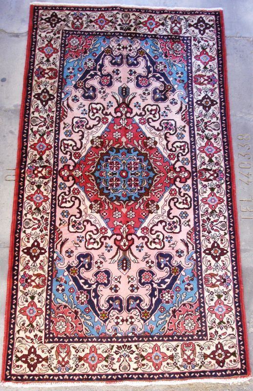 Tappeto persiano Ardebil, disegno Heriz, di vecchia manifattura, con colori vegetali naturali, fondo beige a motivo geometrico e fiori stilizzati, con medaglione blu e bordura rossa, cm 300x196