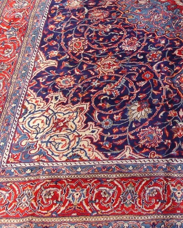 Tappeto persiano Sarugh, di vecchia manifattura, fondo blu, campo a motivo floreale multicolore, con medaglione centrale e bordura rossa, cm 400x300