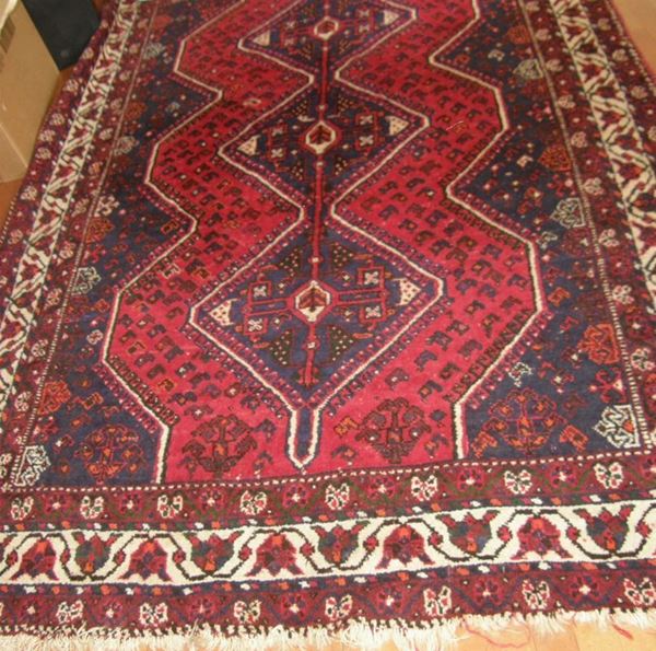Tappeto fondo blu e rosso a tre losanghe e bordura avorio a corolle di      fiori sfalzate, cm 171x252