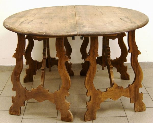 Tavolo ovale, Toscana, sec. XIX, in noce, quattro gambe a lira riunite da traversa, cm 142x132, con tre prolunghe