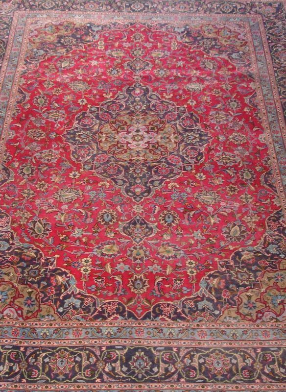 Tappeto persiano Keishan, di vecchia manifattura, fondo rosso a motivo floreale multicolore, con medaglione centrale e bordura blu, cm 345x245