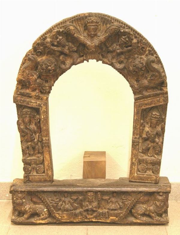 Torana in legno intagliato, Nepal o area himalayana, fine XIX, inizi XX secolo, composto da quattro elementi composti ad incastro, decorato a intaglio con immagini di divinitÃ  induiste, brevi iscrizioni sulla base, cm 80x60