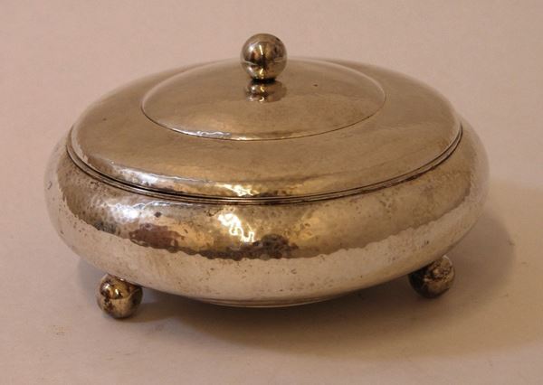 Bomboniera, in argento, dal corpo bombato e martellato, con coperchio, poggiante su tre piedi sferici, diam. cm 20, gr. 610