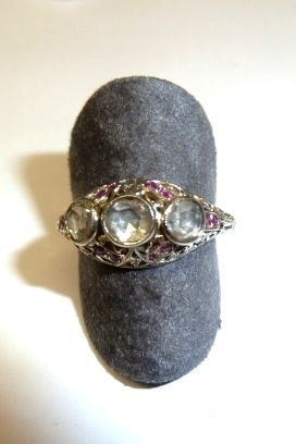 Anello fine sec. XIX, in oro bianco, diamanti e rubini                      la parte anteriore realizzata come una fascia bombata e traforata decorata  da piccolissimi rubini e centrata da tre brillanti di taglio vecchio, g 3,  un brillante scheggiato sul bordo