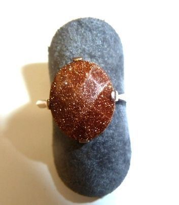 Anello in oro a basso titolo e avventurina  ovale  al centro montata entro castone a griffe, g 2