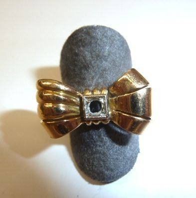 Anello in oro giallo                                                        la parte superiore modellata come un fiocco centrato da una piccola pietra  ad imitazione del diamante, g 7, pietra da rimontare
