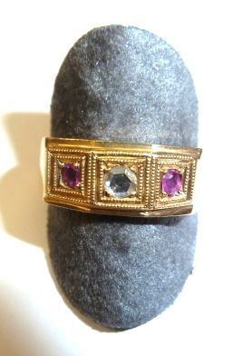 Anello in oro giallo, rubini e diamante                                     realizzato come una fascia in oro giallo decorata da due rubini ed un       piccolo brillante posti in linea montati entro castoni quadrati cesellati a doppia cornice, g 8