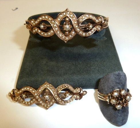 Parure in oro rosa e microperle composta di bracciale, spilla e anello, Il bracciale a cerchio rigido e la spilla a barretta analogamente decorati  da un motivo a nastri intrecciati decorato in microperle, l'anello decorato da piccole perle disposte a formare una corolla, g 30, mancanze(3)