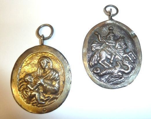 Due pendenti, sec. XIX, in argento                                          di forma ovale rispettivamente cesellati a San Giorgio e il drago e a       Vergine con Bambino, g 27 (2)