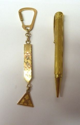 Portachiavi in oro giallo, g 14;  ed un portamine, inizi sec. XX,                                                                                       rivestito in oro giallo inciso a motivi geometrici e cesellato a motivi     fogliacei (2)