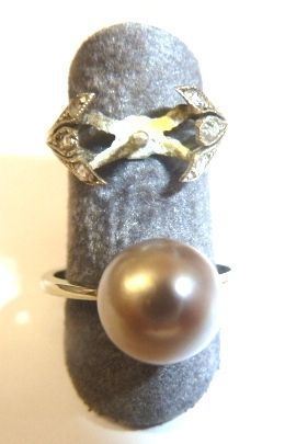 Anello in oro bianco e perla                                                al centro una perla diam. mm 9, ed una montatura per                        anello in oro bianco e piccole rose di diamante, g 5                        (2)