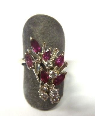 Anello in oro bianco, diamanti e rubini                                     decorato da un motivo a tralcio stilizzato realizzato in piccoli brillanti, diamanti taper e rubini di taglio navette, g 5