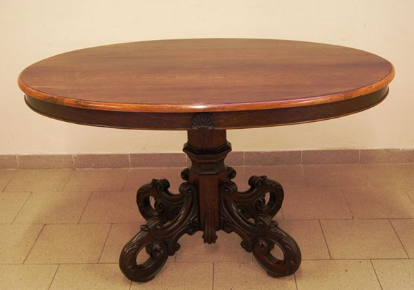 Tavolo ovale, Napoli, sec. XIX, in palissandro, fusto centrale con quattro gambe sagomate a volute, cm 130x90x77