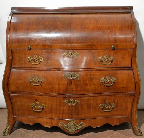 Bureau a cylindre, Francia inizi sec. XIX,in mogano con interni in quercia  e applicazioni in bronzo dorato, piano scrittoio scorrevole che aziona il   meccanismo di apertura del cilindro, scarabattolo con prospetto             architettonico e vani a giorno, fronte bombato a tre cassetti, pendaglina   sagomata frontale e laterale, gambe sinuose con scarpette in bronzo dorato, cm 114x57x113