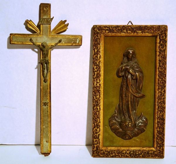 Crocefisso in bronzo su croce in legno dipinto con profili dorati, cm 28,5x13, danni e mancanze, ed una formella in bronzo modellata a Vergine ed applicata su pannello rettangolare in velluto con cornice in legno dorato, cm 24,5x13,5 (2)