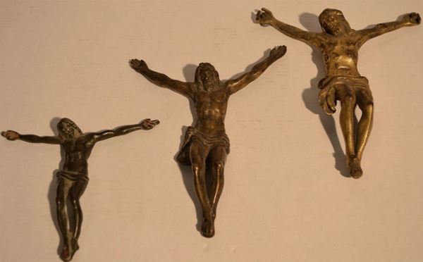 Tre Crocefissi in bronzo e bronzo dorato, cm 17,5x13,5; cm 16,5x12,5; cm 10,5x11,5 (3)