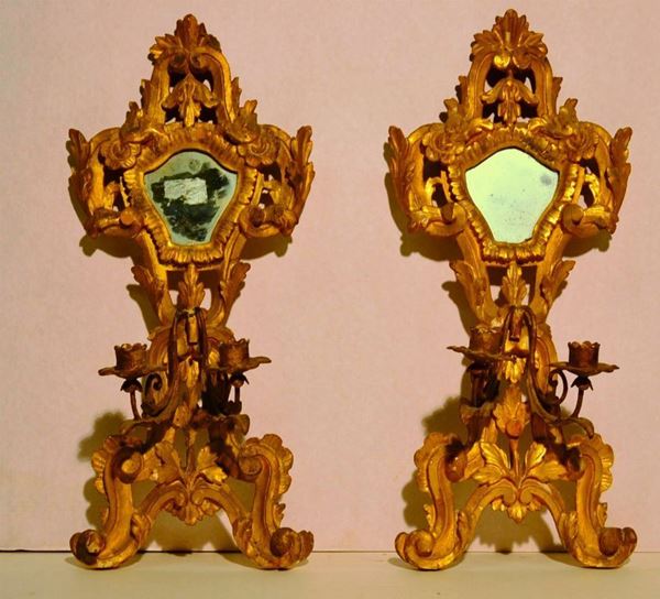 Coppia di appliques, sec. XIX, in legno intagliato e dorato, ciascuna a due braccia portacandele, cm 43x19 , danni (2)