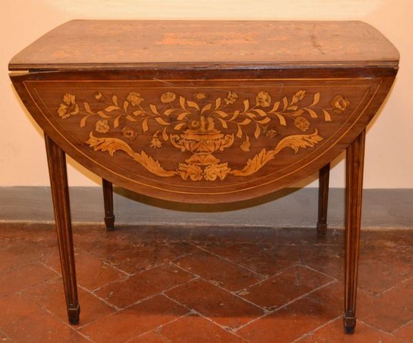 Tavolino, Olanda, inizi metÃ  sec. XIX, in mogano intarsiato e filettato,    piano ovale a bandelle centrato da ricco motivo floreale inscritto in       cornici e decorato da tralci di foglie di acanto e farfalle, gambe          troncopiramidali scannellate, aperto cm 107x143x74