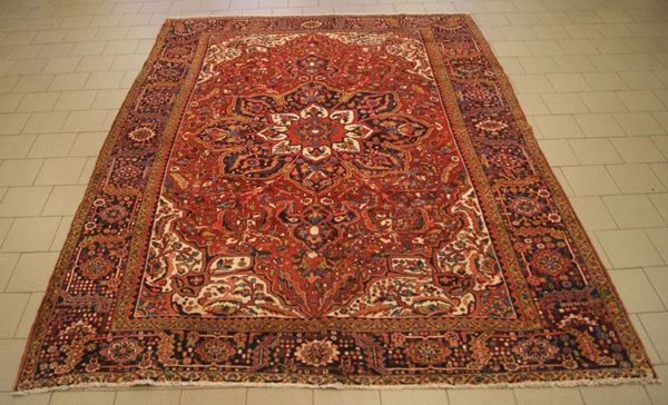 Tappeto persiano heriz, di vecchia manifattura, con colori vegetali naturali, fondo rosso, campo a motivo geometrico e fiori stilizzati, con grande medaglione centrale e bordura multicolore, cm 400x300