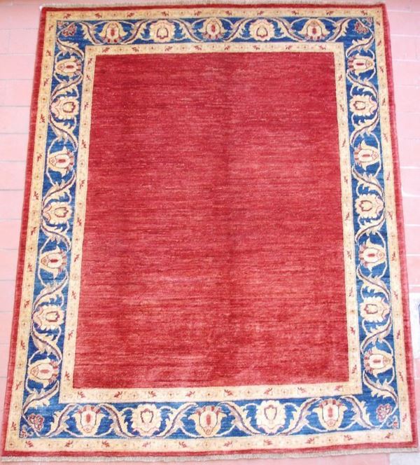 Tappeto ghazny zygler, fondo rosso in tinta unita, colori vegetali naturali, bordura a motivo vegetale in blu e giallo oro, cm 230x185