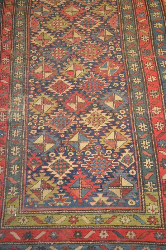 Galleria, fondo blu a motivo geometrico, quattro bordure nei toni del rosso, del verde e del blu a motivi floreali stilizzati, cm 310x103, consunto